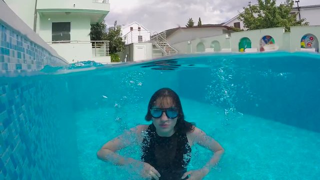 woman with long hair dives into the pool