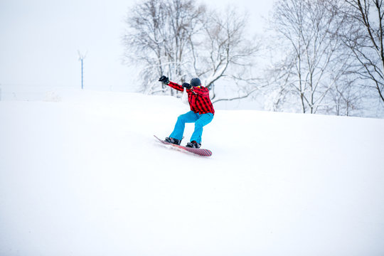 Image of snowboarder man riding snowy hill