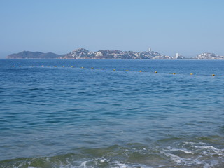 Beauty panorama of Pacific Ocean waves on sandy beach at bay of ACAPULCO city in Mexico