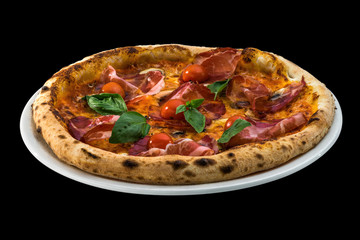 pizza with cherry tomatoes, prosciutto and basil isolated on black background