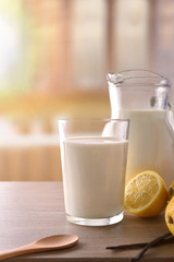 Glass of milk on wooden bench in rustic kitchen vertical