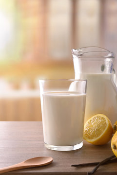 Glass of milk on wooden bench in rustic kitchen vertical