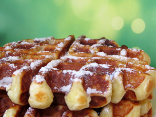 Stack of Belgian waffles on a blurred green background