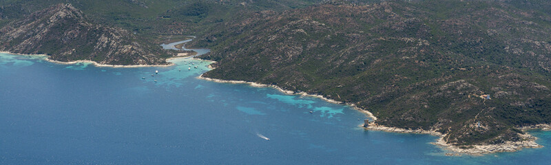 Fototapeta premium Aerial image of turquoise blue waters at the Corsican coastline West of Saint-Florent showing Punta Cavallata and Plage du Lotu