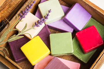 Jabones artesanales de colores dentro de una caja de madera. Vista superior