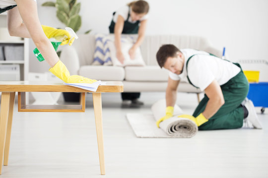 Man rolling carpet while cleaning
