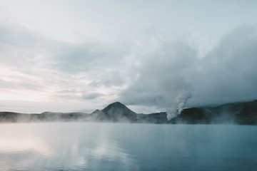 majestic icelandic seacoast with rocky mountains and steam from hot springs
