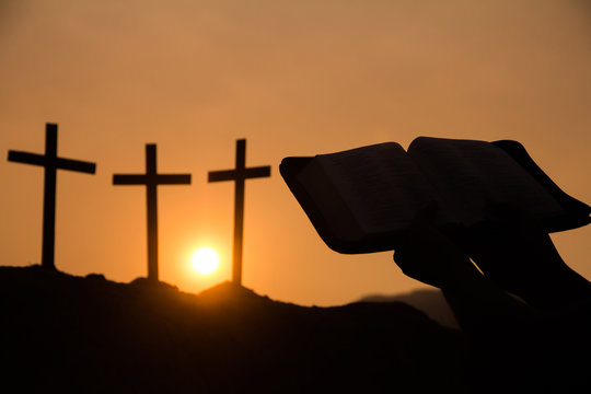  Image silhouette of a christian person reading a bible with rosary, Sunset background., Religion concept.