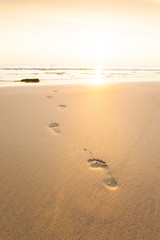 Footprints on the sunset beach.