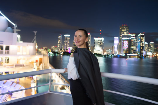 Business woman smile on ship board at night in miami, usa. Sensual woman in suit jacket on city skyline. Fashion, beauty, look. Travelling for business. Wanderlust, adventure, discovery, journey.