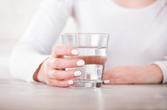Female hand holding glass of water