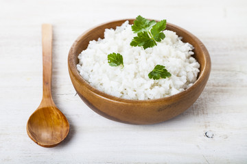 Boiled rice in a wooden bowl and spoon