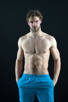 Man athlete show muscular torso in blue shorts, fitness