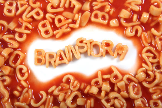 The word 'Brainstorm' written in alphabetti spaghetti, orange pasta shaped letters.