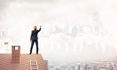 Man architect draw silhouette of modern city on blue sky. Mixed 