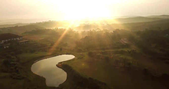 Beautiful aerial landscape of palm oil plantation and lake at sunrise time in Sukabumi, West Java, Indonesia. Shot in 4k resolution