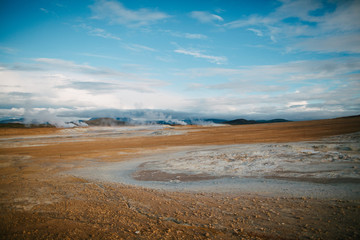 Fototapeta na wymiar spectacular view of rocky plain and geothermal steam from hot springs in iceland