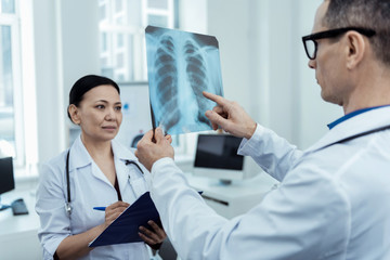 Accurate glance. Professionall doctor holding a radio scan while detecting problems