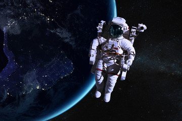 Obraz na płótnie Canvas Astronaut in outer space on background of the night Earth. Elements of this image furnished by NASA.