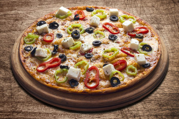 Hot pizza slice with melting cheese on a rustic wooden table.