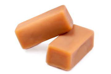 Caramel treats isolated on white. Golden Butterscotch toffee candy caramels.