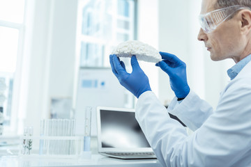 Detect disorders. Close up of brain scan in hands of a professional neurosurgeon