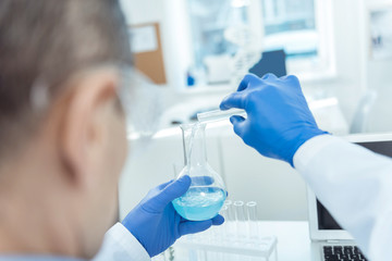 Add it here. Professioanl researcher distributing liquid while working in a lab