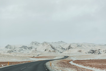 empty asphalt road and beautiful snow-covered mountains in iceland