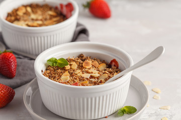 Homemade summer breakfast strawberry crumble. Mini berry cake with strawberry, light background. Healthy vegan food concept.