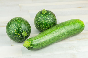 Varieties of green zucchini on wooden table