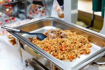 Containers with hot food at the banquet. Pilaf, chicken, beef, vegetables - hot dishes, self-service. buffet breakfast