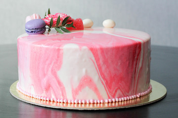 Tasty pink homemade cake decorated by rose and macarons