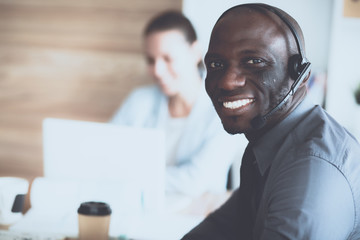 Business people with headsets using computers in office