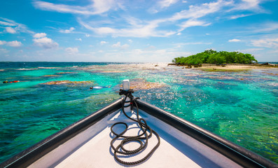 Boat and snorkeling people in lagoon. Islet in Fakarava lagoon, French Polynesia