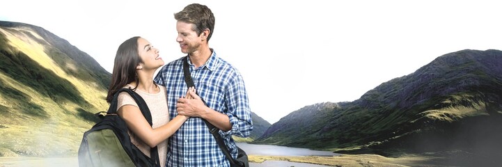 Travelling couple with bags in front of landscape