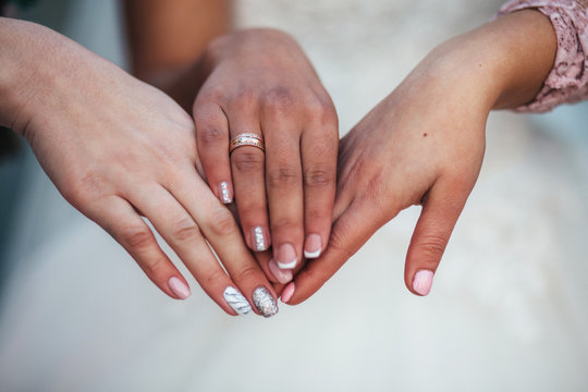 Bride and bridesmaids hold their hands together
