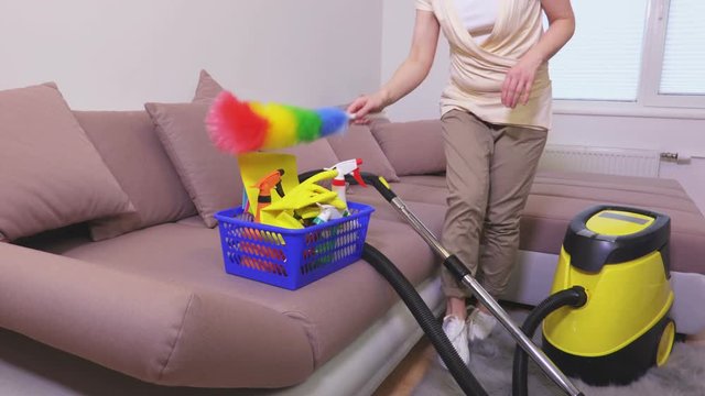 Woman remove dust from sofa