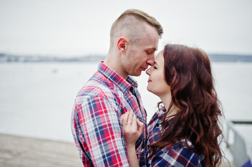 Stylish couple wear on checkered shirt in love together.