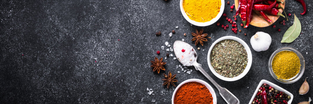 Set Of Various Spices And Herbs On Black Stone Table.