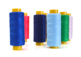 Spool of coloured thread isolated on white background.