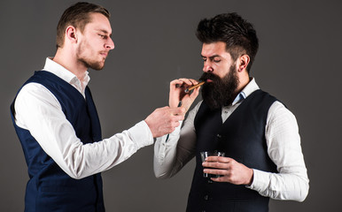 Friend, business partner, assistant helping man with beard light cigar.