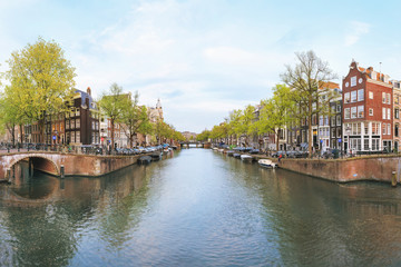Fototapeta na wymiar Canals of Amsterdam. Sunset view of traditional bridge