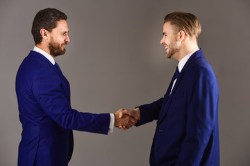 Men in suits or businessmen hold hands each other