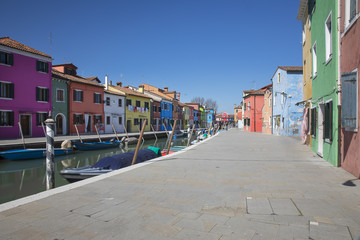 Fototapeta na wymiar Typical canal with colorful facades with vibrant colors in famous fishermen village on the island of Burano, Venice, Italy