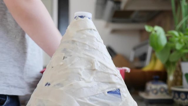 Dolly of a little boy creates a volcano out of paper mache