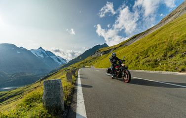 Motorcycle driver riding japanese high power cruiser in Alpine highway on famous Hochalpenstrasse,...