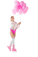 Young girl wearing pink roller blades holding balloons isolated on white