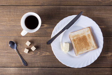 Composition with butter coffee and toasts on wooden table