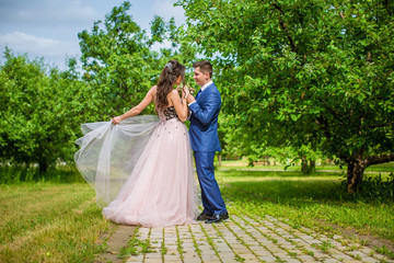 Newlyweds are walking in park in summer. Romantic walk