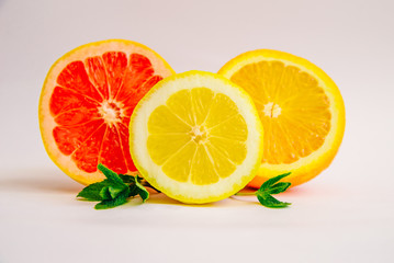 Grapefruit, lemon and orange in a cut on a white background.